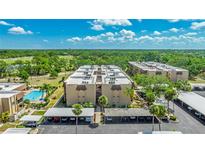 An exterior view of a condo building with a swimming pool and carport parking at 1330 Glen Oaks E Dr # 374D, Sarasota, FL 34232