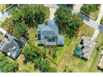 An aerial view of a house with a screened pool, mature trees, and a well-maintained yard at 13615 4Th Ne Ave, Bradenton, FL 34212