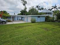 Charming blue home with a well-manicured lawn and attached two-car garage at 1654 Blakemore Ln, Sarasota, FL 34231