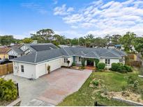 Charming single-story home with lush landscaping, brick driveway, and solar panels at 1828 Mova St, Sarasota, FL 34231