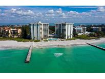 Stunning aerial view of beachfront condos with a pristine sandy beach and turquoise ocean waters at 2301 Gulf Of Mexico Dr # 26N, Longboat Key, FL 34228