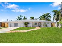 Charming single-story home featuring a brick walkway, lush lawn, and well-maintained landscaping at 2311 Sunnyside Pl, Sarasota, FL 34239