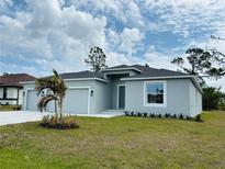 Charming single-story home with a three-car garage, lush lawn, and a decorative palm tree at 5113 Rilke Ln, Port Charlotte, FL 33981