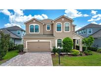 Charming two-story home with a paver driveway, well-maintained lawn and lush landscaping at 5252 Bentgrass Way, Bradenton, FL 34211