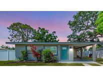 Charming single-story home with well-maintained landscaping, vibrant plants, carport and a teal front door at 5732 Beneva Rd, Sarasota, FL 34233