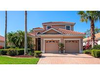 Charming home features a red tile roof, brick driveway, manicured landscaping and a 2 car garage at 6442 Tailfeather Way, Bradenton, FL 34203