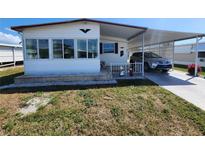 Charming single-story home featuring an attached carport, well-maintained lawn, and welcoming front porch at 808 53Rd E Ave # 234, Bradenton, FL 34203