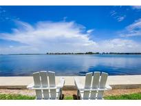 Relaxing waterfront view with two white Adirondack chairs on the water at 117 7Th N St # 5, Bradenton Beach, FL 34217