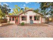 Charming home featuring red window frames and an inviting brick paved driveway at 1721 8Th Street, Sarasota, FL 34236