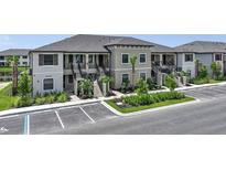 Beautiful condo exterior featuring stairs leading to the units, manicured landscaping, and convenient parking at 23819 Collina Way # 102, Port Charlotte, FL 33980
