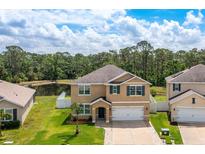 Two-story home featuring a well-manicured lawn and pond view at 259 Tierra Verde Way, Bradenton, FL 34212