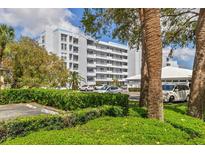A multi-story condo building with a well-maintained lawn and mature trees and shrubs at 3790 Pinebrook Cir # 408, Bradenton, FL 34209