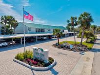 Welcome to White Sands Village featuring a manicured entrance and covered parking at 5663 Midnight Pass Rd # 407, Sarasota, FL 34242