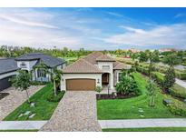 Stunning single-Gathering home featuring a tile roof, paver driveway, lush landscaping, and a two-car garage at 5810 Brandon Run, Bradenton, FL 34211