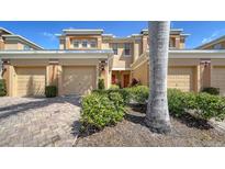 Attractive townhome featuring a two-car garage, lush landscaping, and a welcoming entrance at 5356 Mang Pl # 1404, Sarasota, FL 34238