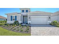 Charming single-Gathering home featuring a paved driveway, two-car garage, and well-manicured lawn at 10027 Cross River Trl, Parrish, FL 34219