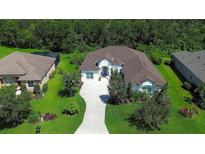 Stunning home features a manicured lawn, mature trees, and a charming exterior design at 13130 50Th E Ct, Parrish, FL 34219