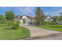 Stunning home features lush landscaping, a blue front door, and a winding driveway, adding to its curb appeal at 13130 50Th E Ct, Parrish, FL 34219