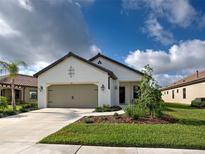 Charming single-story home featuring a two-car garage, neutral paint, dark accents, and manicured landscaping at 208 Potenza Loop, Nokomis, FL 34275