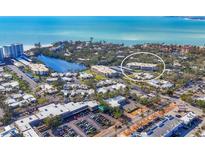 Scenic aerial view of a beachfront community with blue water and lush tropical landscaping at 225 Hourglass Way # 306, Sarasota, FL 34242