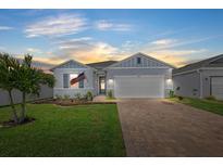 Charming single-story home featuring a well-manicured lawn and a brick driveway leading to a two-car garage at 3443 74Th Avenue E Cir, Sarasota, FL 34243