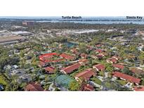 An aerial view of villas with red roofs and a tennis court, near Turtle Beach and Siesta Key at 3740 Pinecone Ct # 163, Sarasota, FL 34238