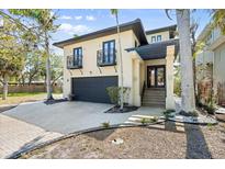 Contemporary home with a two-car garage, second-story balconies, and a landscaped yard at 4964 Commonwealth Dr, Sarasota, FL 34242