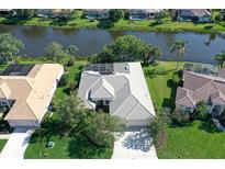 This aerial view showcases a lovely single-story home with a tile roof and screened-in lanai overlooking a serene waterway at 5032 Timber Chase Way, Sarasota, FL 34238