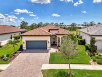 Beautiful single-Gathering home featuring a tile roof, paver driveway, and a well-manicured lawn at 6267 Crested Eagle Ln, Nokomis, FL 34275