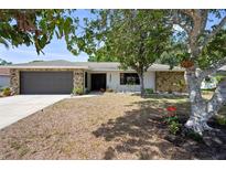 Beautiful single-story home with stone facade, mature trees, and a well-maintained lawn at 6604 23Rd W Ave, Bradenton, FL 34209