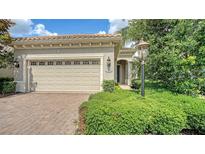 Charming home featuring a two-car garage, brick paved driveway, and well-maintained landscaping at 7158 Westhill Ct, Lakewood Ranch, FL 34202