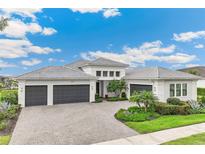 Beautiful single-Gathering home with a three-car garage and a well-manicured front yard at 8936 Artisan Way, Sarasota, FL 34240