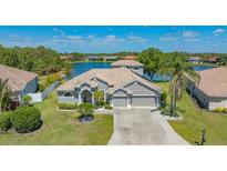 Stunning lakefront property featuring a tile roof, well-manicured lawn and three-car garage at 1085 Mallard Marsh Dr, Osprey, FL 34229