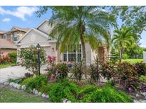 Charming home with lush landscaping, tropical plants, and a well-manicured lawn at 15032 Skip Jack Loop, Lakewood Ranch, FL 34202