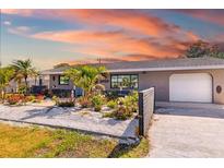 Charming single-story home featuring a lush, meticulously landscaped front yard and one car garage at 2929 Siesta Dr, Venice, FL 34293