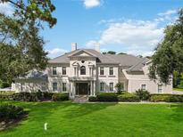 Elegant two-story home featuring a lush green lawn, manicured landscaping, and a stately entrance at 340 Osprey Point Dr, Osprey, FL 34229