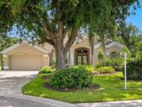 Charming single-story home with a beautiful landscape, mature trees, and a well-manicured lawn at 355 Melrose Ct, Venice, FL 34292