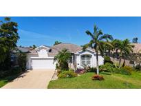 Beautiful single-Gathering home featuring a well-manicured lawn, palm trees, and a two-car garage at 5022 46Th W St, Bradenton, FL 34210