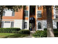 Exterior view of building with orange paint, stone accents, black railings and lush landscaping at 8325 38Th Street E Cir # 101, Sarasota, FL 34243