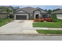 Charming single-story home with a well-manicured lawn and a two-car garage on a sunny day at 11092 58Th Street Cir E, Parrish, FL 34219