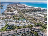 Stunning aerial view of waterfront community with beaches, docks and residences on a clear, sunny day at 1235 Dockside Place # 108, Sarasota, FL 34242
