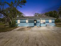 Charming single-story home featuring a flat roof, blue exterior and a spacious driveway at 13241 Miami St, Hudson, FL 34667