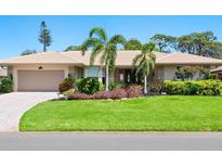 Inviting single-story home featuring mature landscaping, a well manicured lawn, and a neutral color palette at 142 Dory Ln, Osprey, FL 34229