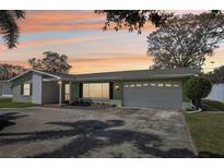 Charming single-story home features a two-car garage, lush lawn, and a welcoming front entrance at 1440 S Keene Rd, Clearwater, FL 33756
