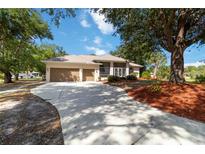 Charming single-story home featuring a circular driveway, manicured landscaping, and an attached two-car garage at 1860 Citron St, Punta Gorda, FL 33980