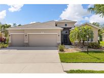 Charming home featuring a well-manicured lawn, a three-car garage, and stone accents at 2819 130Th E Ave, Parrish, FL 34219