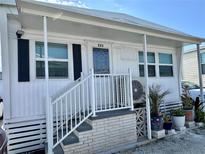 Charming single-story home featuring an inviting front porch with white railings and well-maintained landscaping at 3710 Gulf Of Mexico Dr # E22, Longboat Key, FL 34228