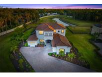 Stunning home with beautiful tile roof, lush landscaping, brick paver driveway, and pond view at 4712 Margutta Ct, Sarasota, FL 34240