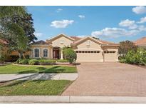Charming home featuring a tile roof, three-car garage, and manicured landscaping under a sunny sky at 5412 Royal Poinciana Way, North Port, FL 34291