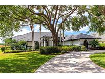 Beautiful single-story home with lush landscaping, mature shade trees, and a circular driveway at 600 Eagle Watch Ln, Osprey, FL 34229